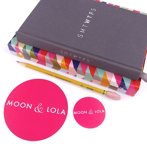Moon and Lola Brand Hot Pink Circle Stickers two sizes shown side-by-side with a notebook and pencil